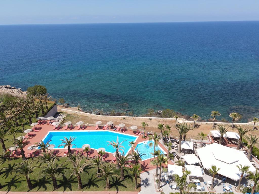 Aerial view of a seafront hotel with a pool and beach