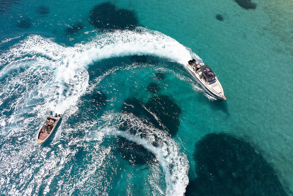 Aerial view of a speedboat leaving a white wake on turquoise water